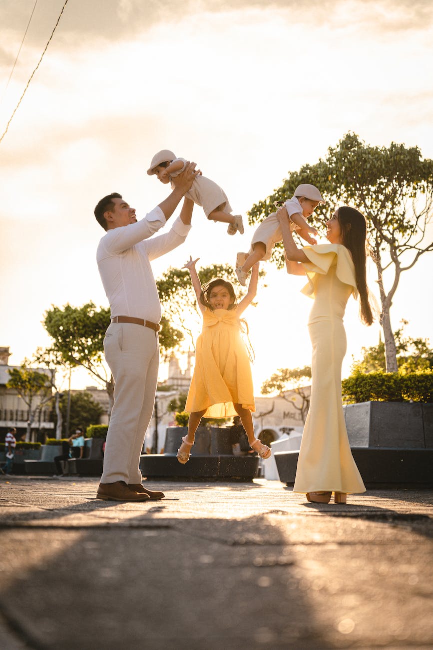 a family with twin baby boys and a daughter posing outdoors
