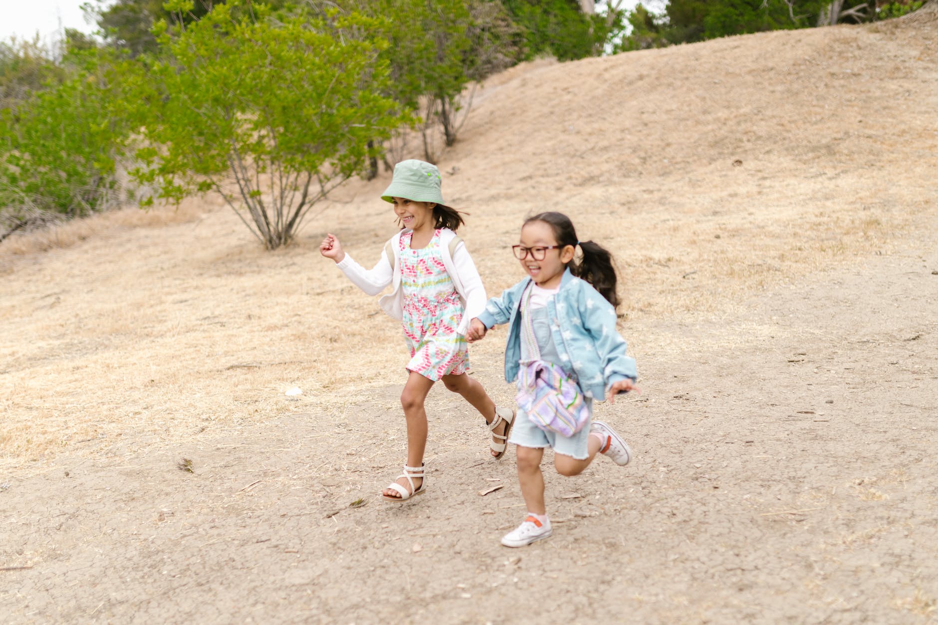 two girls holding hands while running