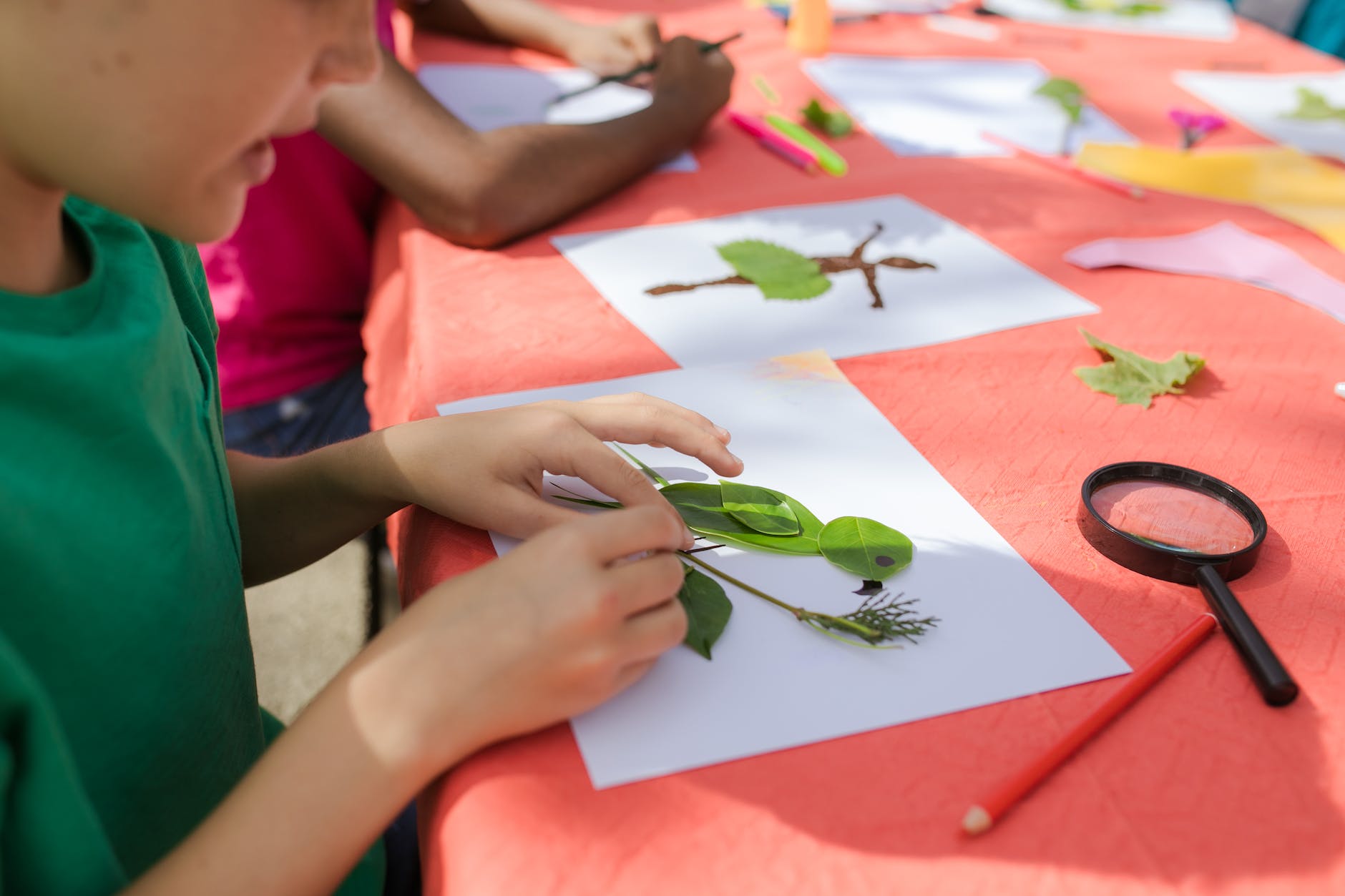 a child making a bird artwork with leaves